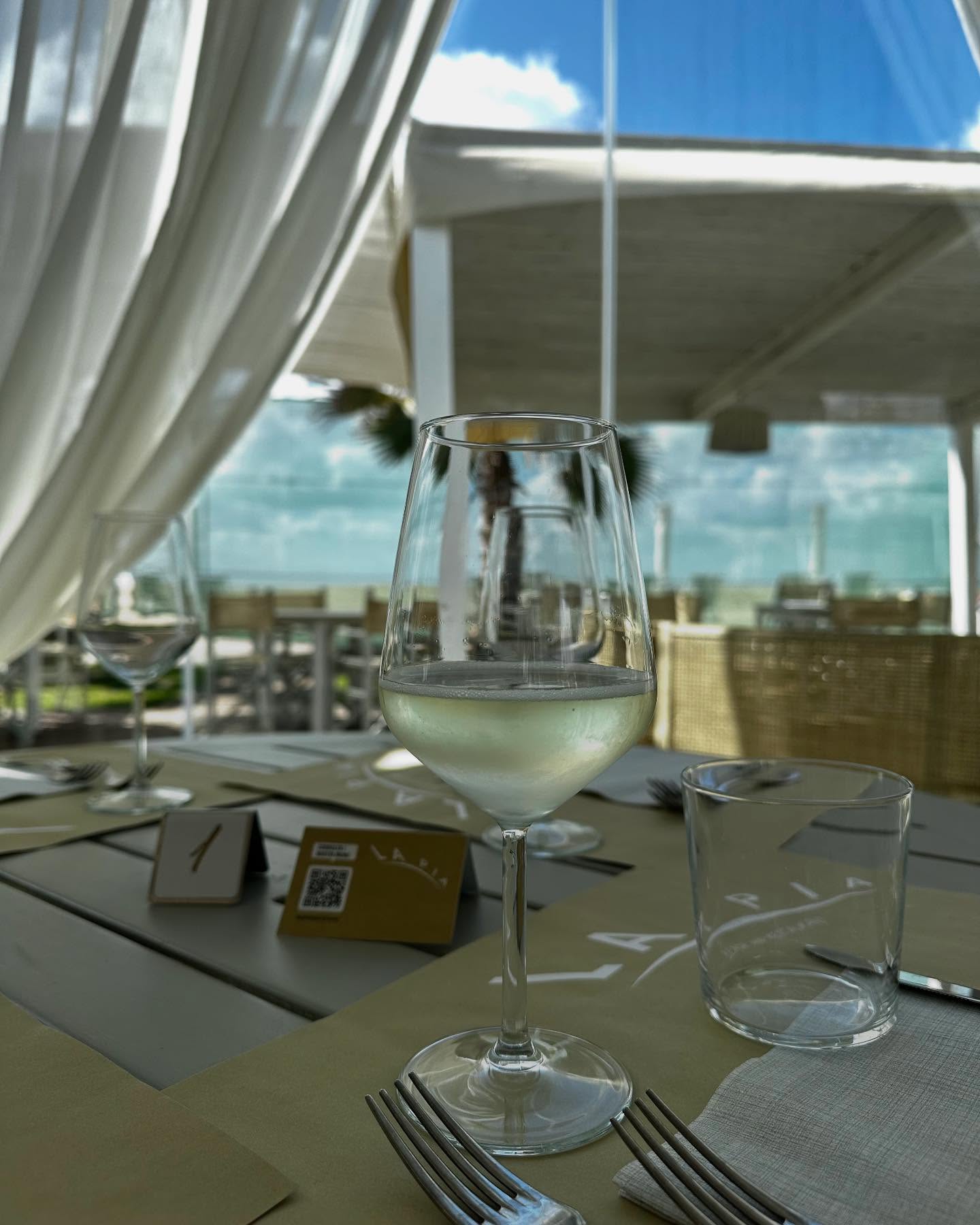 Calice di vino bianco su un tavolo apparecchiato sotto la tenda