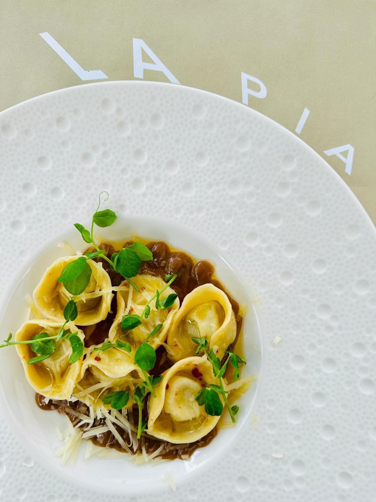 Tortelli di pasta fresca con germogli e grana, nel piatto La Pia